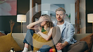 Frightened spouses watching tv sitting at evening. Couple enjoying scary movie