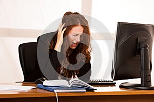 Frightened stressed woman working at her desk in the office, rea