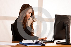 Frightened stressed woman working at her desk in the office, reading bad report
