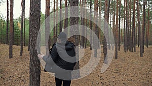 Frightened teen girl running away from pursuit in the forest, running through the trees