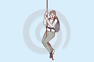 Frightened woman climber hangs on rope and opens mouth from fear, or release of adrenaline in body