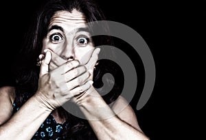 Frightened woman covering her mouth