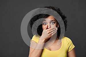 Frightened woman covering her mouth with palm