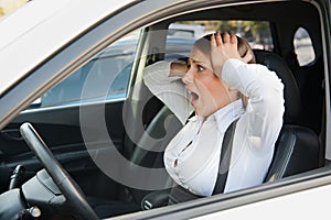 Frightened woman sitting in the car