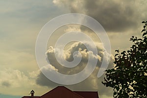 A frightening cloud appeared behind the roof of the house, signaling that it would soon rain, rain or hail. Preparing photo