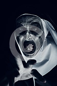 Frightening evil nun with bloody teeth