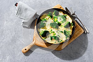 Frittata with broccoli green peas mozzarella cheese frying pan top view