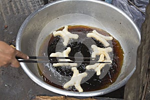 Fritters frying in an oil in a frying pan at a street stall in Phnom Penh