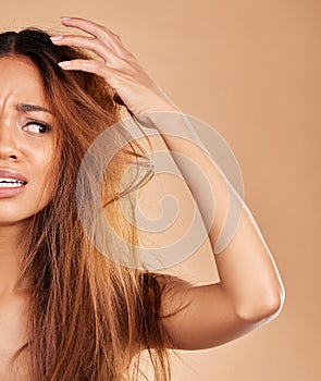 Frizz, messy and woman with a bad hair day isolated on a studio background. Angry, beauty and half of a girl with a