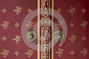 Front of Beautiful red wooden door to Bhutan style background with door knob of gold metal.