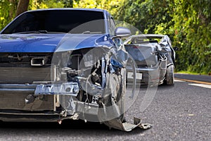 Front of blue color car crash with black car have big damaged and broken by accident on road can not drive any more