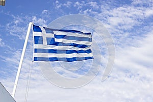 Front bottom shot of colorful waving greece flag with blue open sky background at Izmir in Turkey