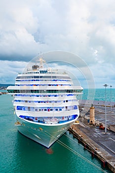 Front bow of large white cruise ship docked in port.