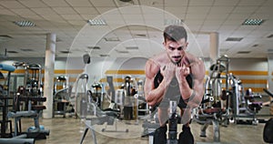 In front of the camera bodybuilding man working on his body he doing a abs exercises to get a perfect muscle in a gym
