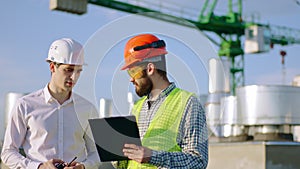 In front of the camera closeup businessman and architect analyzing the plan of construction site they discussing