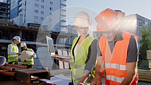 In front of the camera foreman middle-aged with the engineer woman together analyzing and checking the plan of