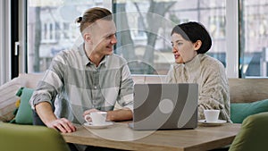 In front of the camera group of attractive couple at the coffee shop discussing together while analysing something on