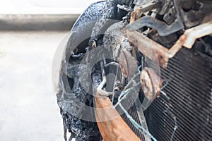 Front of the car after an accident on the road, melted bumper after a fire