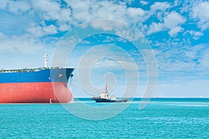 Front of cargo ship sailing in the sea with Tugboat assistance near bow