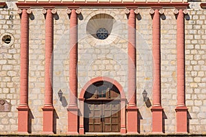 The front of the church at Old Santa Barbara Mission with rustic wood door and classical architectural elements