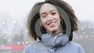 Front closeup portrait of authentic mixed race girl African American black woman with curly hair afro style standing on