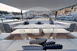 The front deck of huge yacht in port of Monaco at sunset, the place for landing of helicopter, a lot of motorboats are