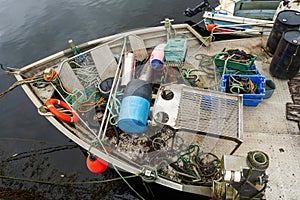 Front deck of a small professional fishing trawler in a harbor. Separation table, empty crates, lines, different shape and color