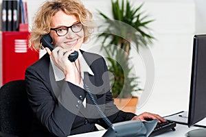 Front desk lady attending clients call photo