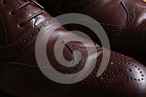 Front detail of a pair of brown leather classic Brogue shoes with lace