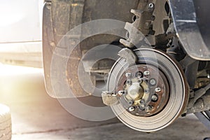 Front disc brake on car with brake caliper process of new tire replacement