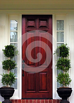 Wood Front Door on upscale home with topiaries