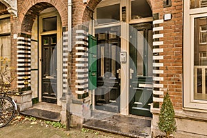 the front door of a brick building with green doors