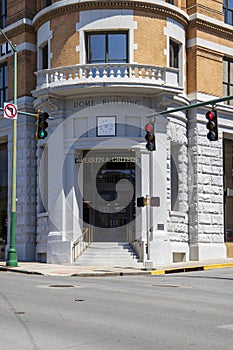 The front door of of The Dome Building with a staircase and traffic signals on the corner of a street in downtown Chattanooga