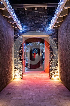 The front door entrance of a home decorated and illuminated for Christmas