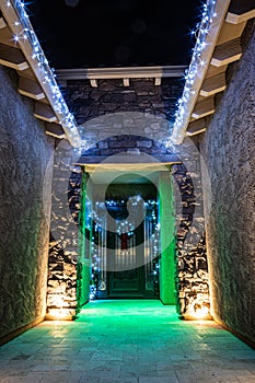 The front door entrance of a home decorated and illuminated for Christmas