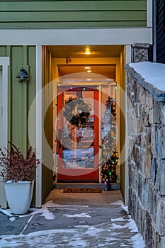 Front door entrance of house with wreath christmas tree and colorful lights