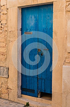 Front door of old house with blue weathered planks