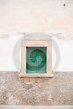 Front door of an old house with green window detail.