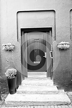 Front door with steps in reykjavik, iceland. House entrance with red door and pot plant decoration. Private property and