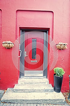 Front door with steps in reykjavik, iceland. House entrance with red door and pot plant decoration. Private property and