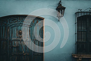 front door and window with safety bars in a blue painted small, old house in Guatemala