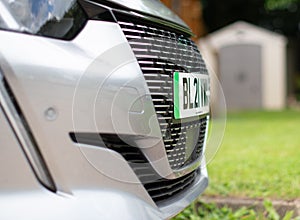 Front end of electric car showing green stripe on the numberplate