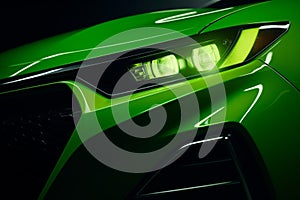 Front end of a green sports car illuminated by its bright headlights, AI-generated.