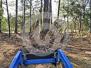 Front end loader hauling stump