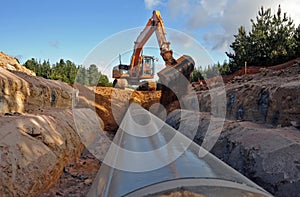 Front end loader operating over a trench constructing a pipeline