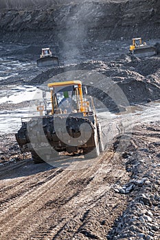 Front-end wheel loader and bulldozers in operation.