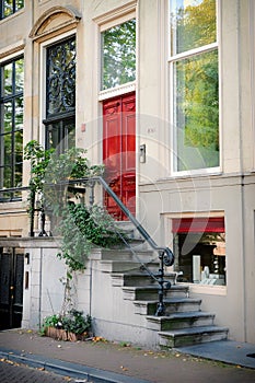 Front entrance door with large windows. Red vintage door with a staircase