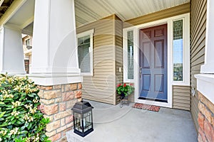 Front entry door with concrete floor porch and flowers pot