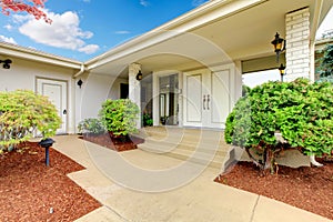 Front exterior entrance to white and beige home with double door