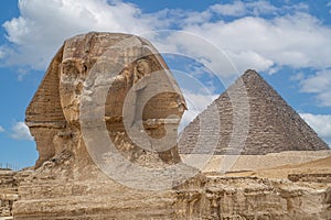 The front face and body of the Sphinx and the biggest Great Pyramid of Khafre appear side by side in the desert of Giza, Cairo,